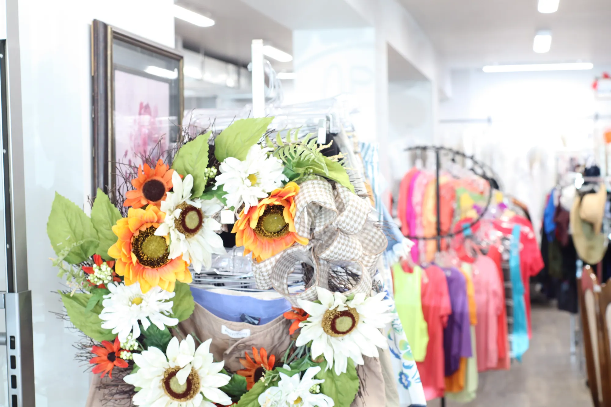 Flower in front of clothes in hospice thrift shop